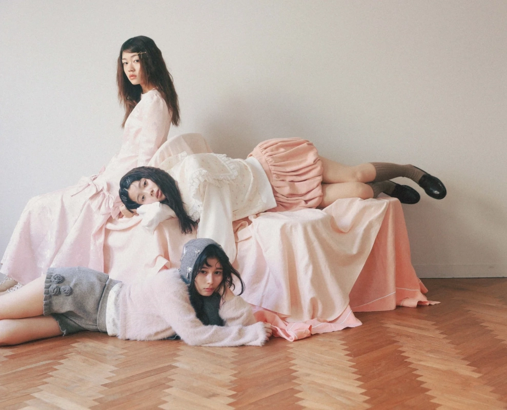 Three young women in pastel outfits