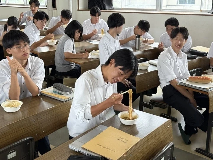 Students eating ramen in a classroom