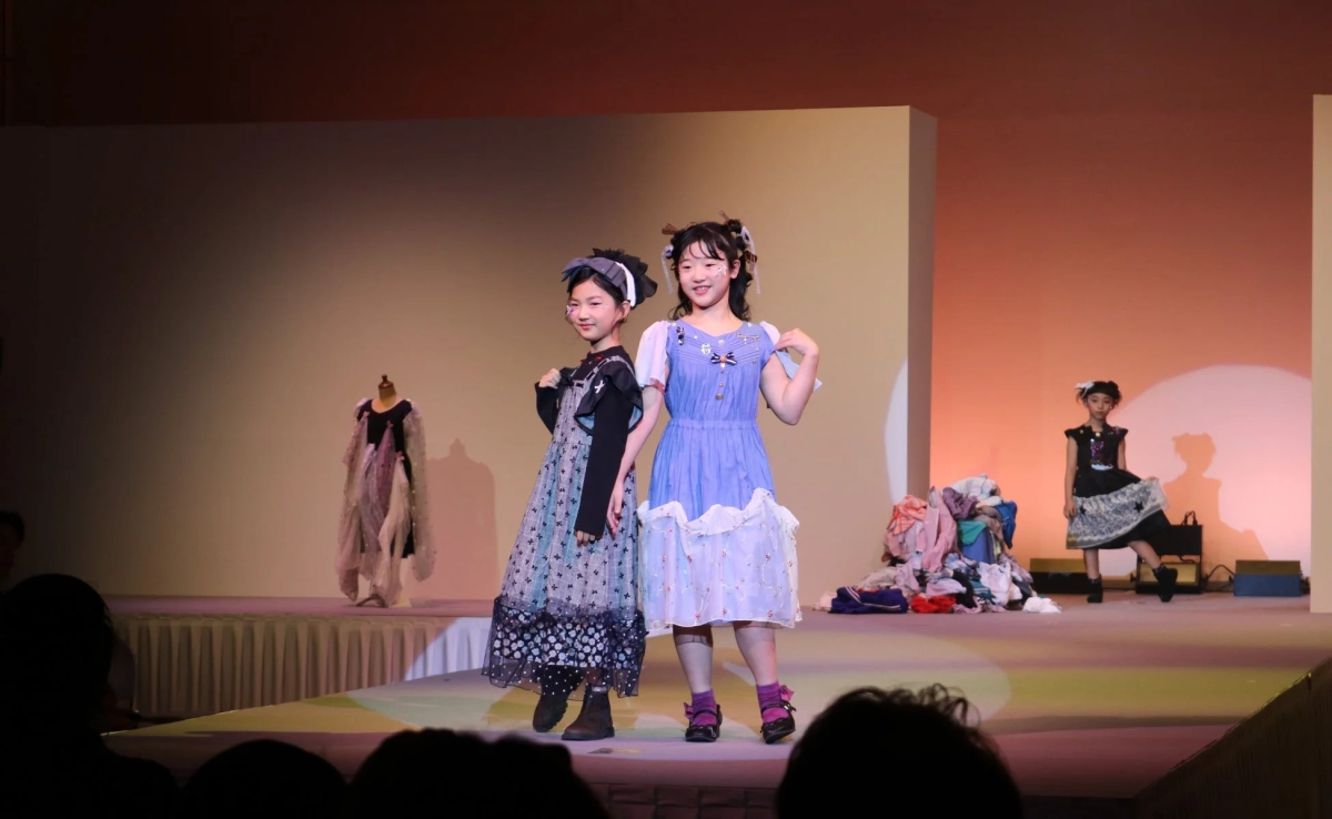 Two girls posing in colorful outfits at the fashion show