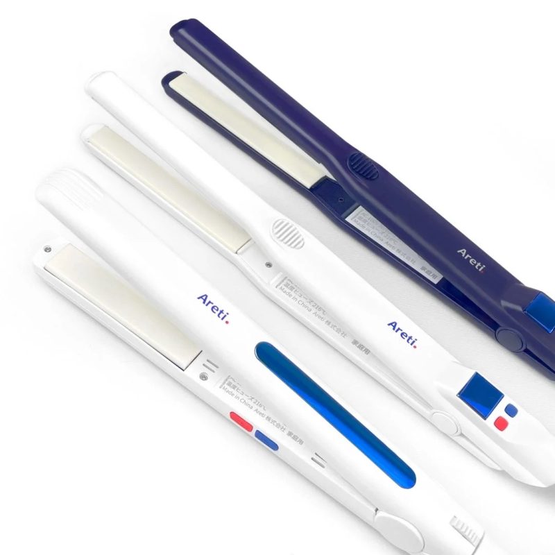 Three white and navy Areti. hair irons on a white background.