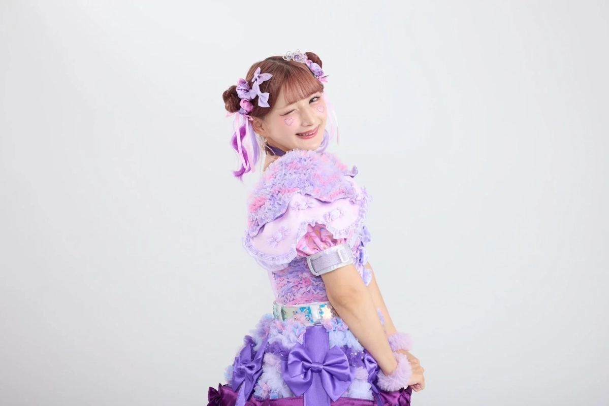 Portrait of Shinako, wearing a purple ruffled outfit and winking