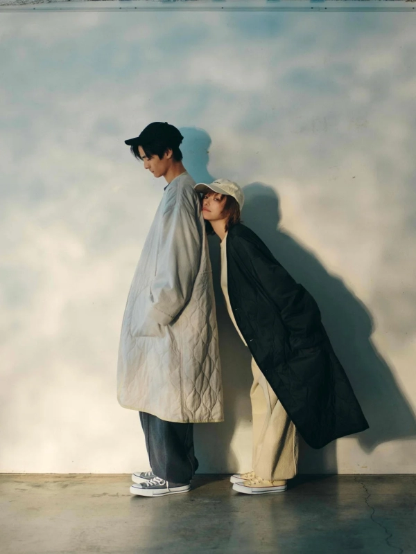 Two models, one in a grey quilted coat and one in a black quilted coat