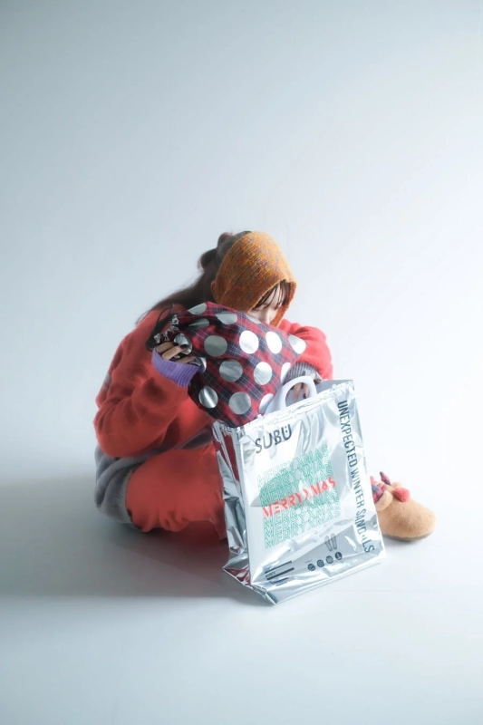 Woman holding SUBU Christmas Gift Bag