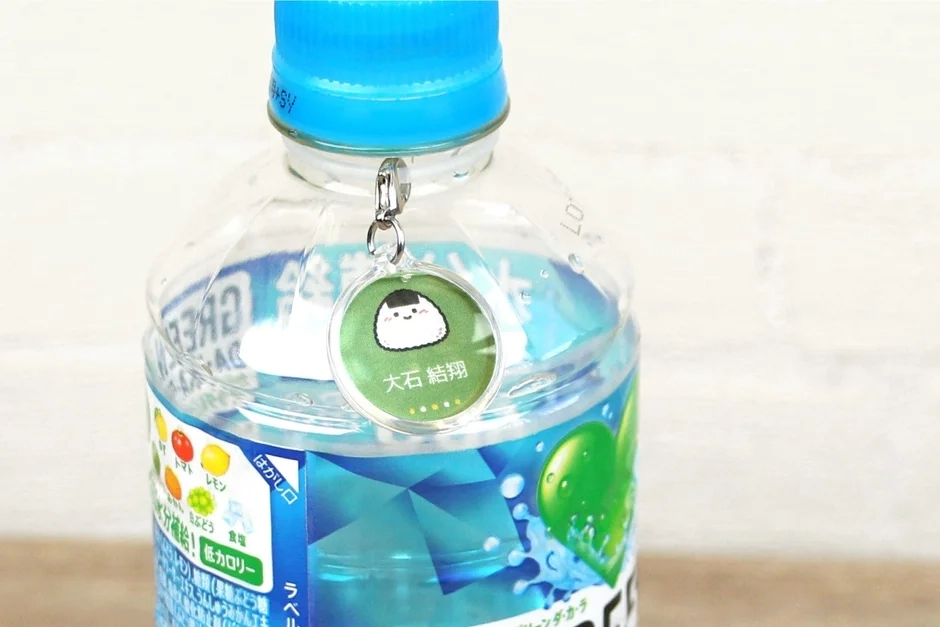 Green charm attached to a blue-capped PET bottle