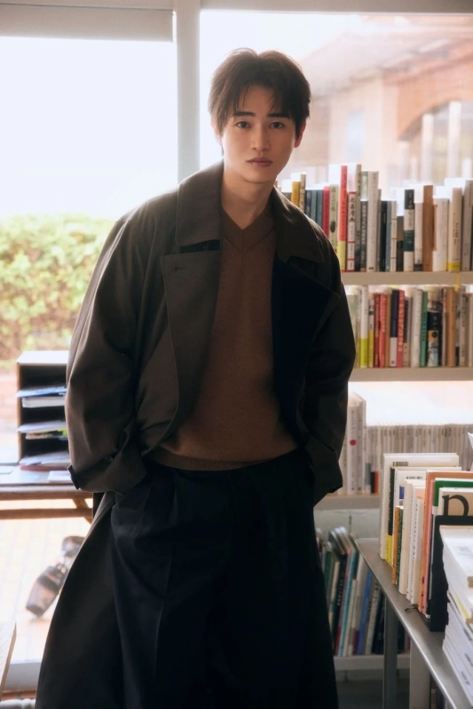 Shou Nishigaki in a coat in a library