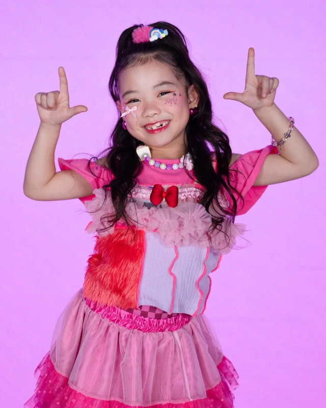 Junna, a girl in a colorful and unique dress, smiling brightly