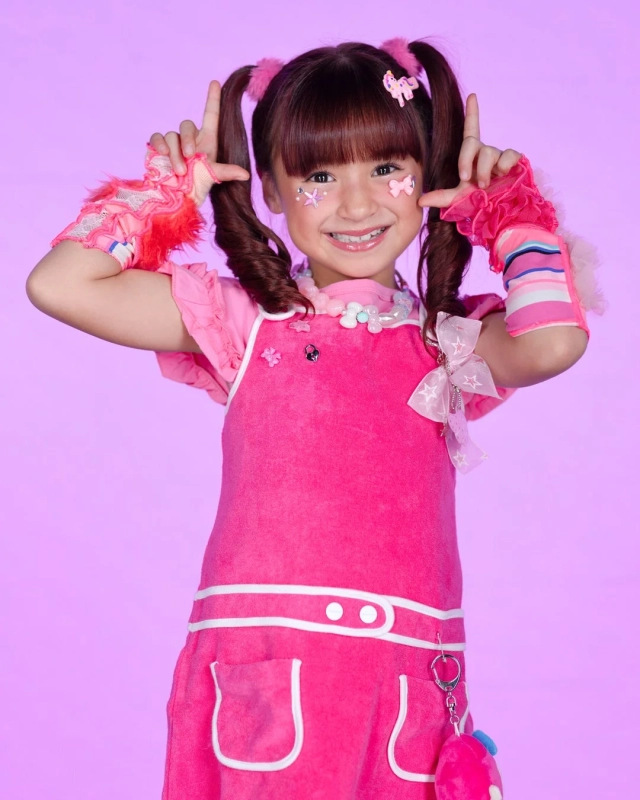 Kojiro, a cute girl in a pink outfit with twin tails, posing with a smile