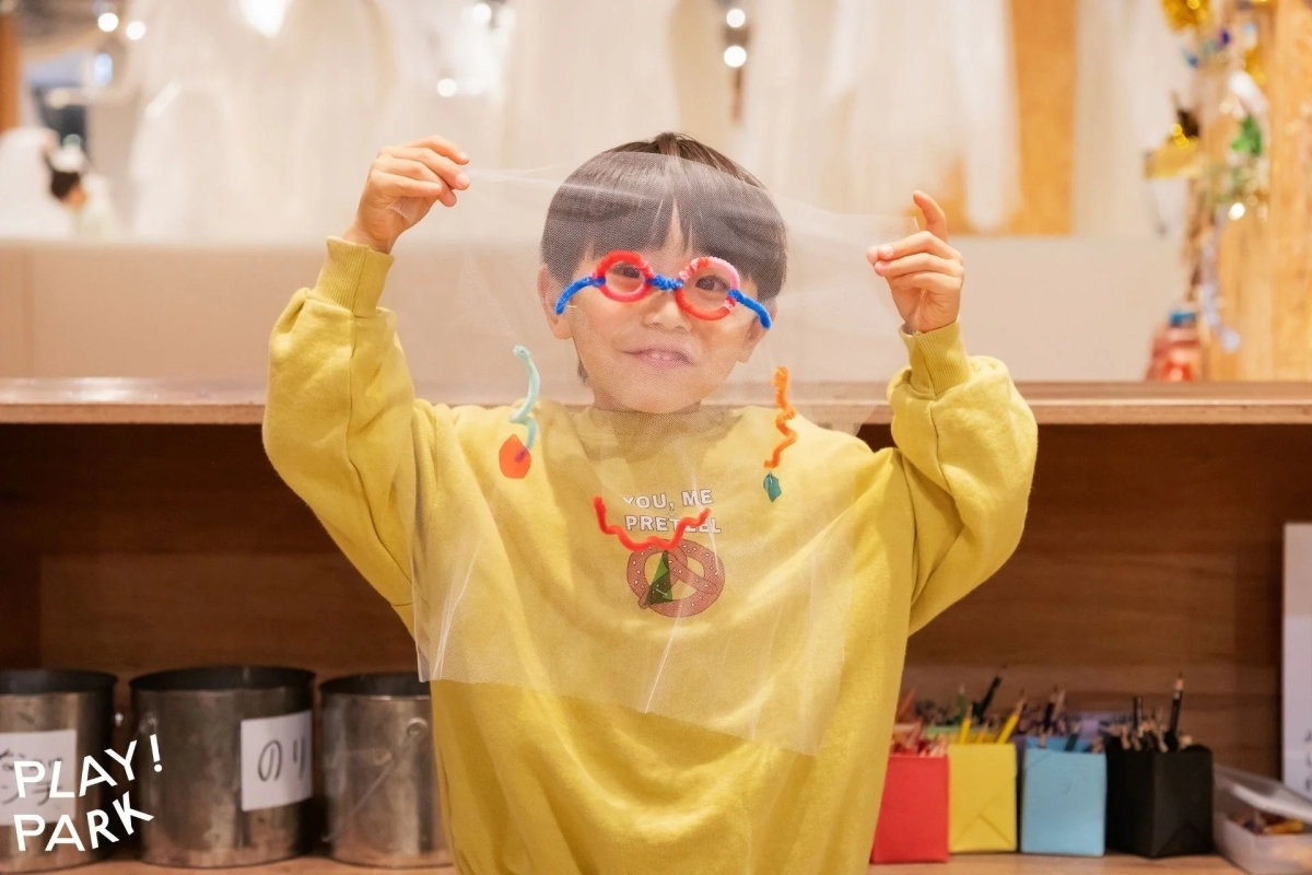 Child holding a decorated tulle fabric