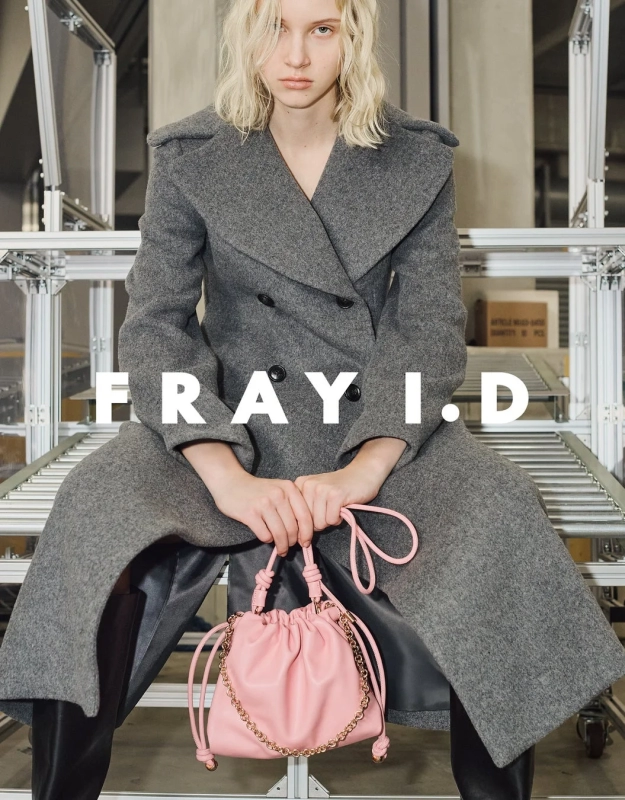 FRAY I.D brand image with model in a grey coat and pink drawstring bag