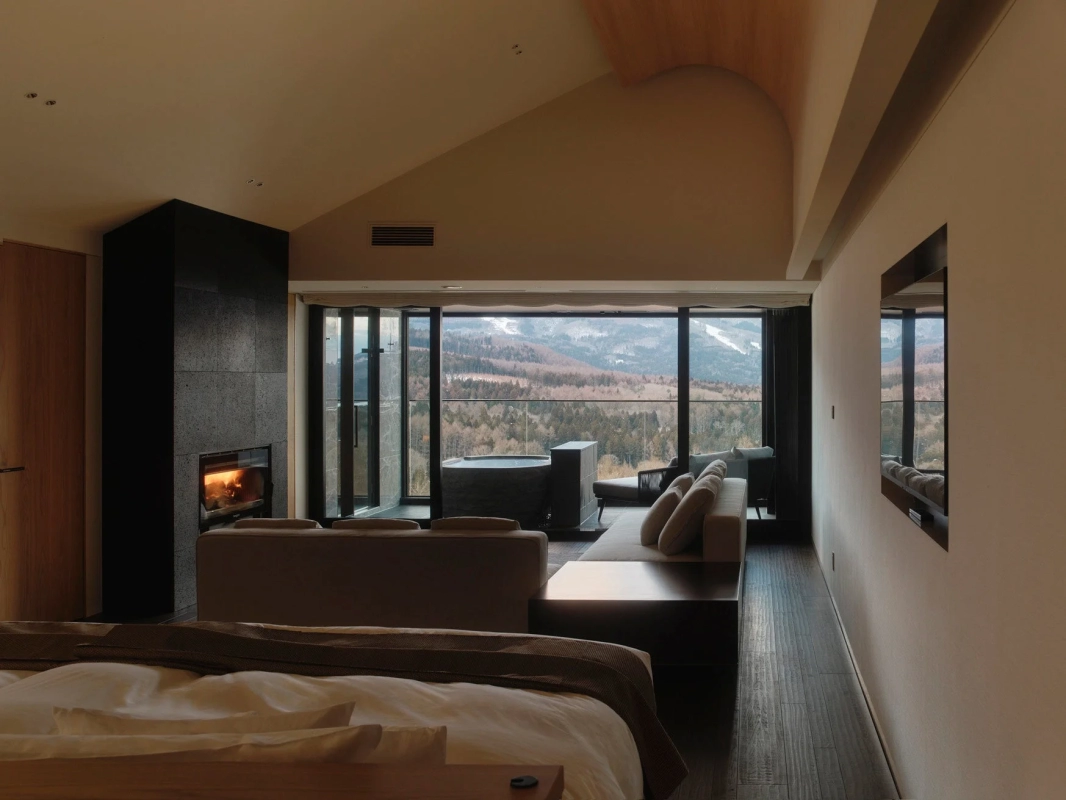 Modern suite with fireplace, large window, and outdoor bath