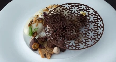 Artistic dessert with chocolate, cream, and nuts