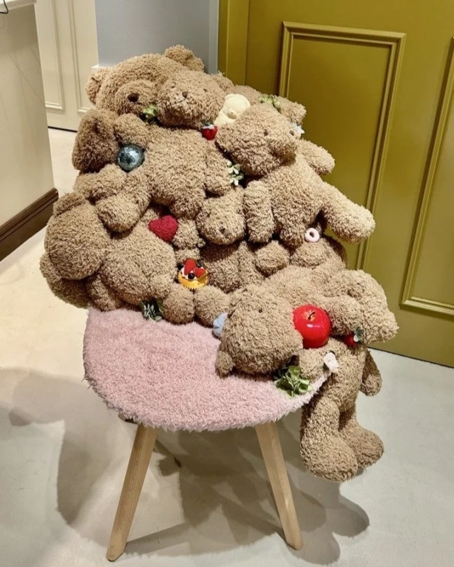 Stacked teddy bears on a chair