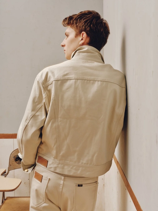 Male model in Lee x ChahChah beige jacket and pants, back view