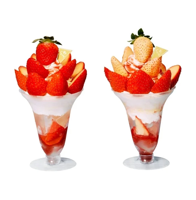 Two parfaits, one with red strawberries and one with a mix of red and white strawberries, beautifully arranged.