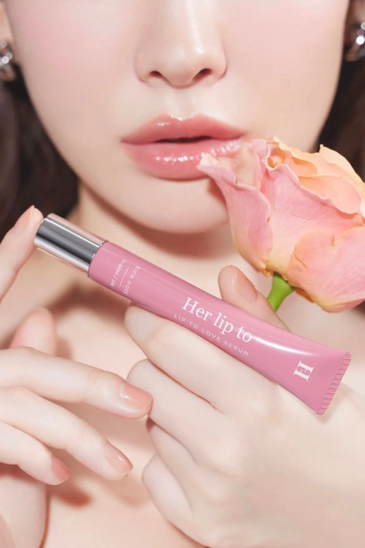 Woman holding lip serum with rose