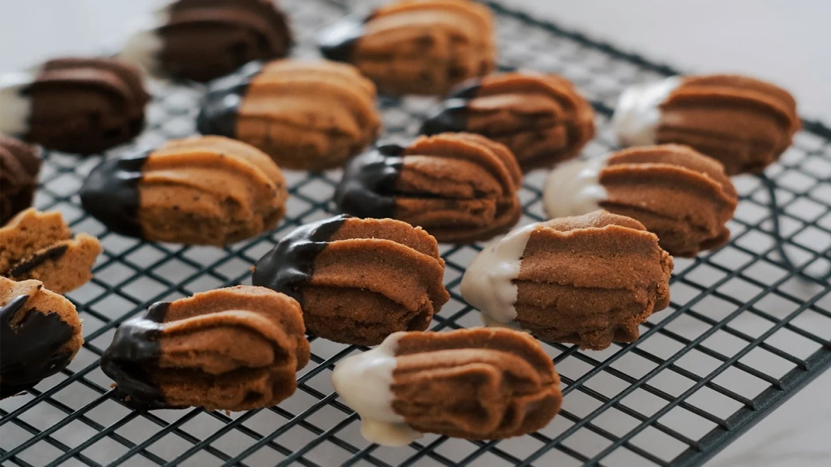 Four different flavors of Bärenpratzen cookies arranged on a cooling rack