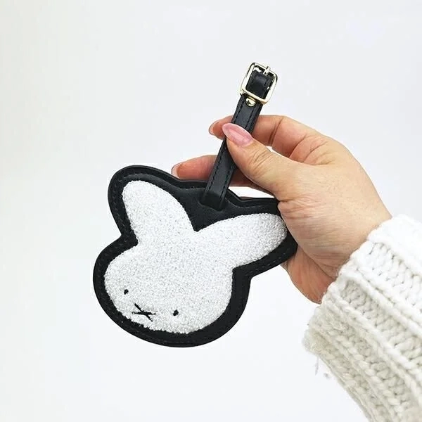 Hand holding Miffy name tag