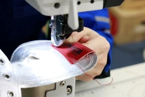 Craftsman sewing a shoe part