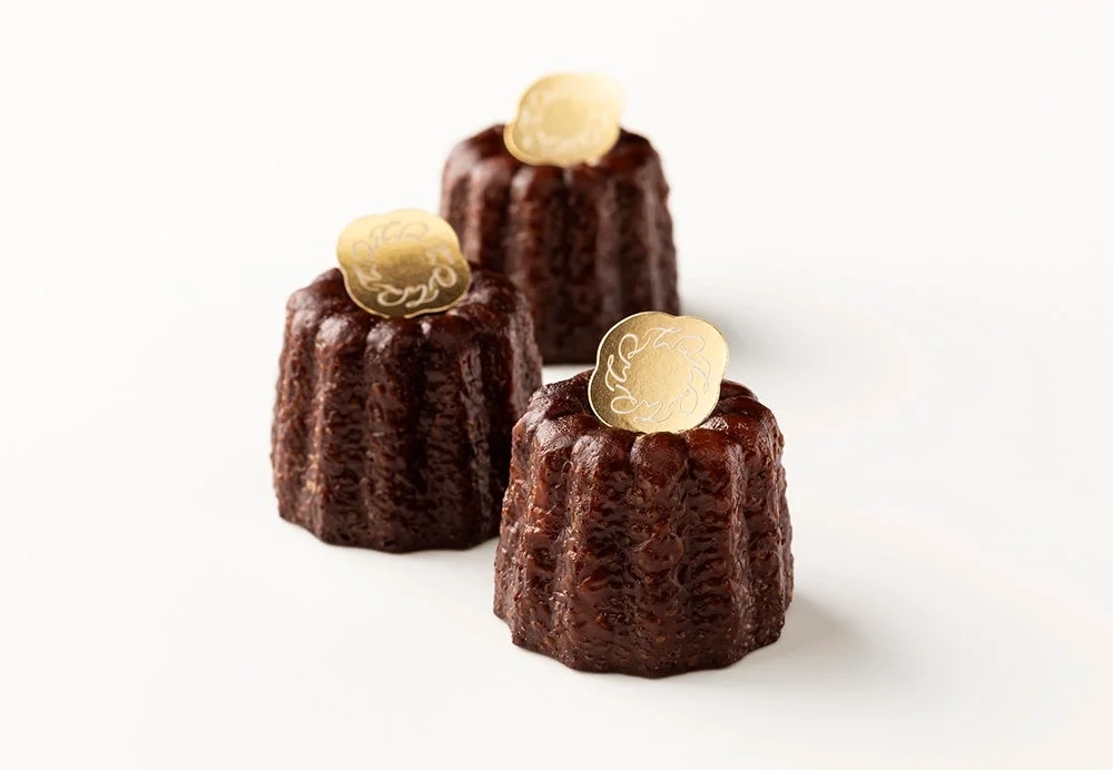 Three Canelés with elegant golden tags