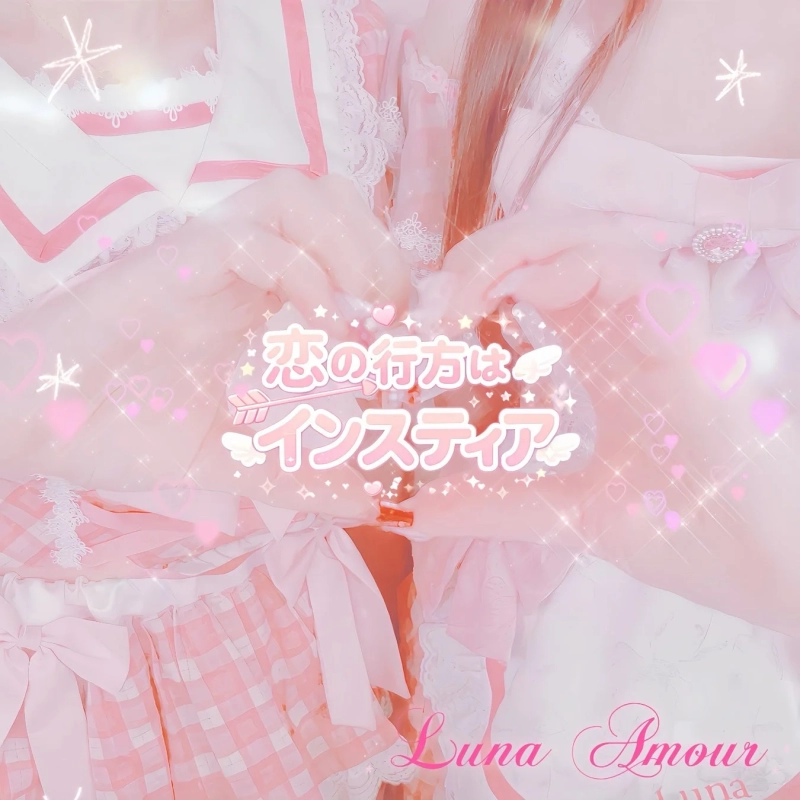 A person in pink and white ruffled/laced costume makes a heart sign with both hands. The image has a glittering, cute, dreamy, and romantic atmosphere.