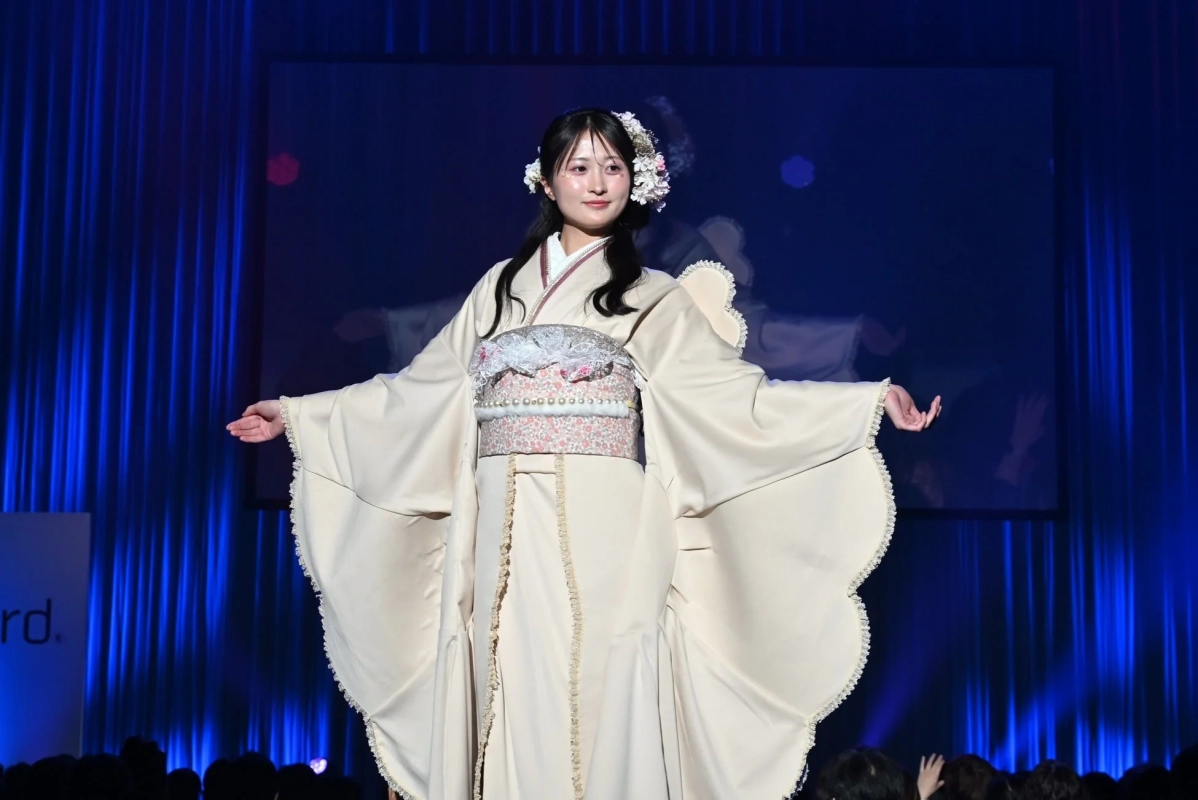 Model in cream modern kimono on stage with floral headpiece