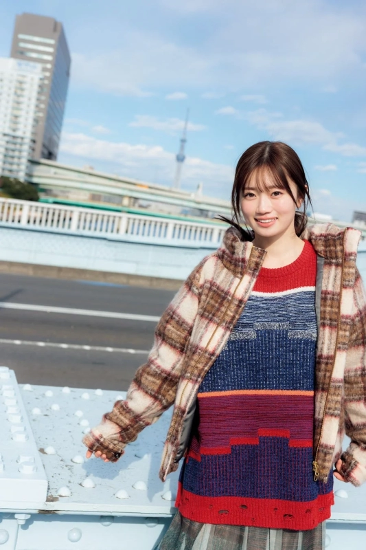 Atago Kokone smiling on a bridge with Tokyo Skytree in background