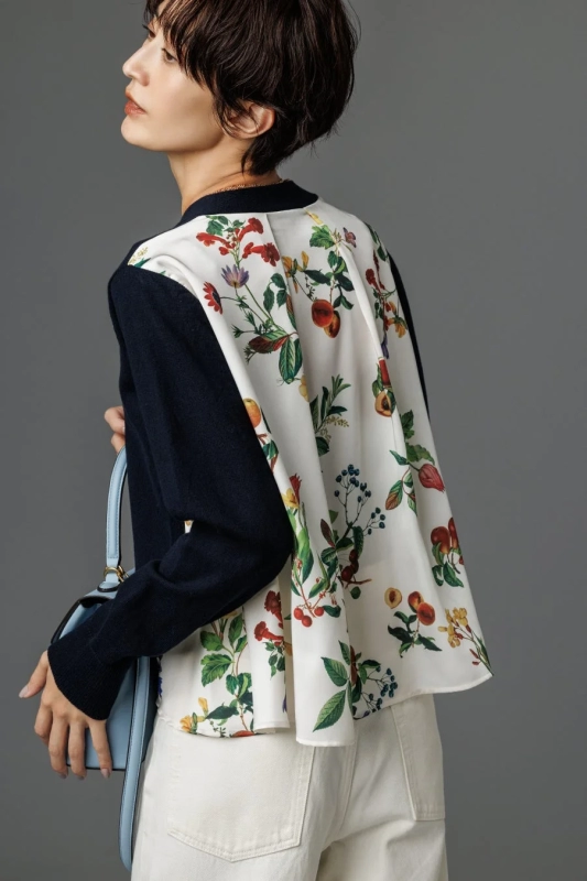 Model in a floral cardigan and white pants