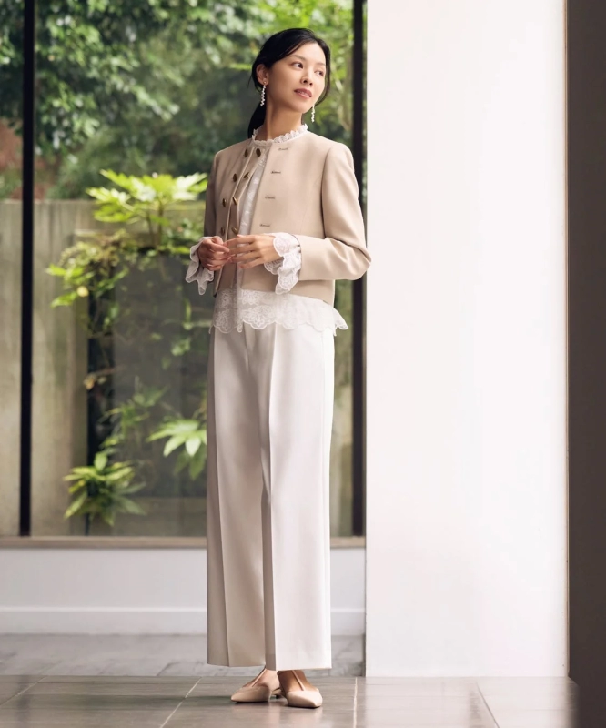 Modern collection piece: Beige jacket, white wide-leg pants, and lace blouse