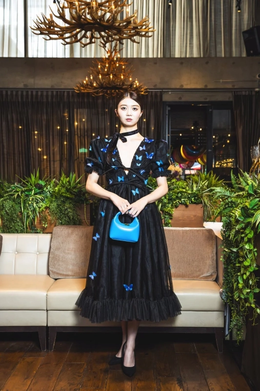 Woman in elegant black dress with blue butterflies