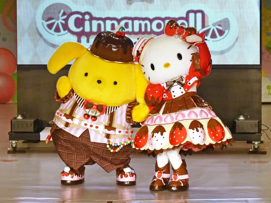 Pompompurin and Hello Kitty on stage in dessert-themed costumes