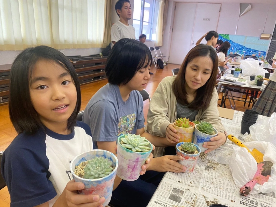 Children and adults engaged in a succulent potting workshop