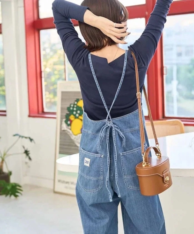 Female model in Lee denim overalls, back view