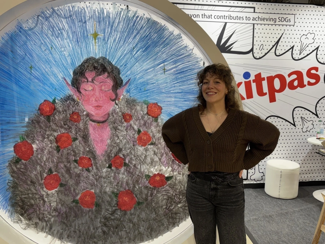 Woman smiling next to a Kitpas art piece
