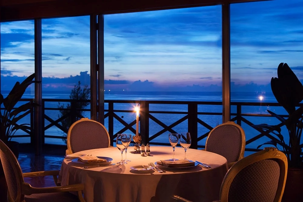 Romantic restaurant interior with ocean view at sunset