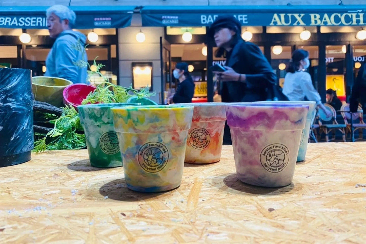 Recycled plastic flowerpots displayed outdoors in an urban setting