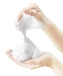 Hands holding rich, white foam