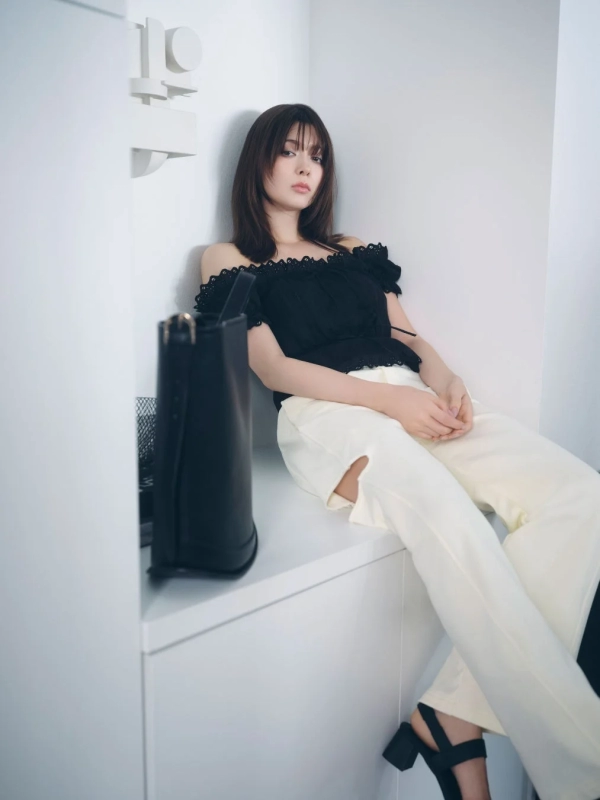 Arisa Yagi in a black off-shoulder blouse and white distressed pants