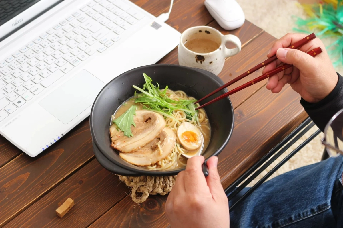 Eating ramen at a desk with a laptop