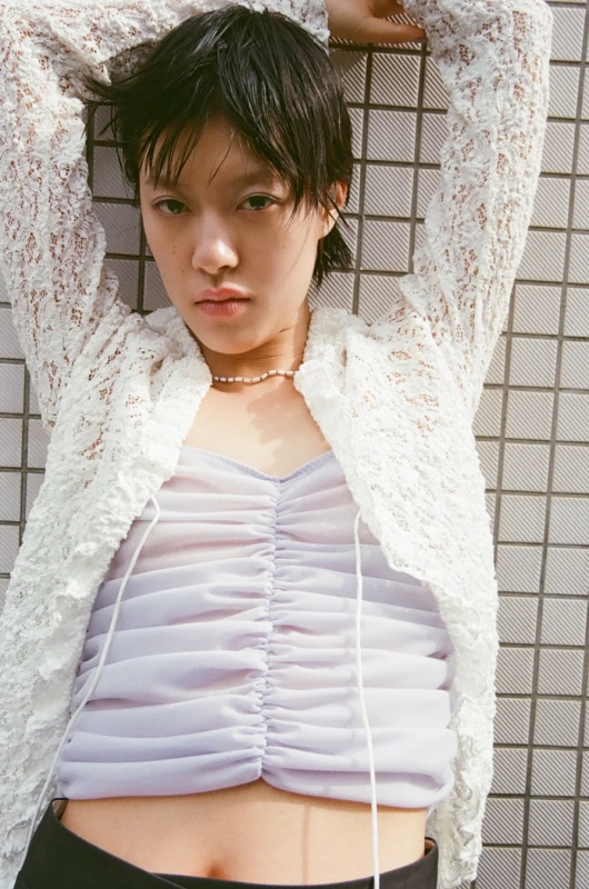 White lace cardigan, purple top, pearls