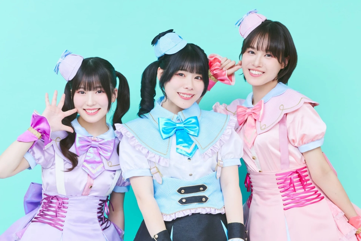 Three female singers in pastel costumes