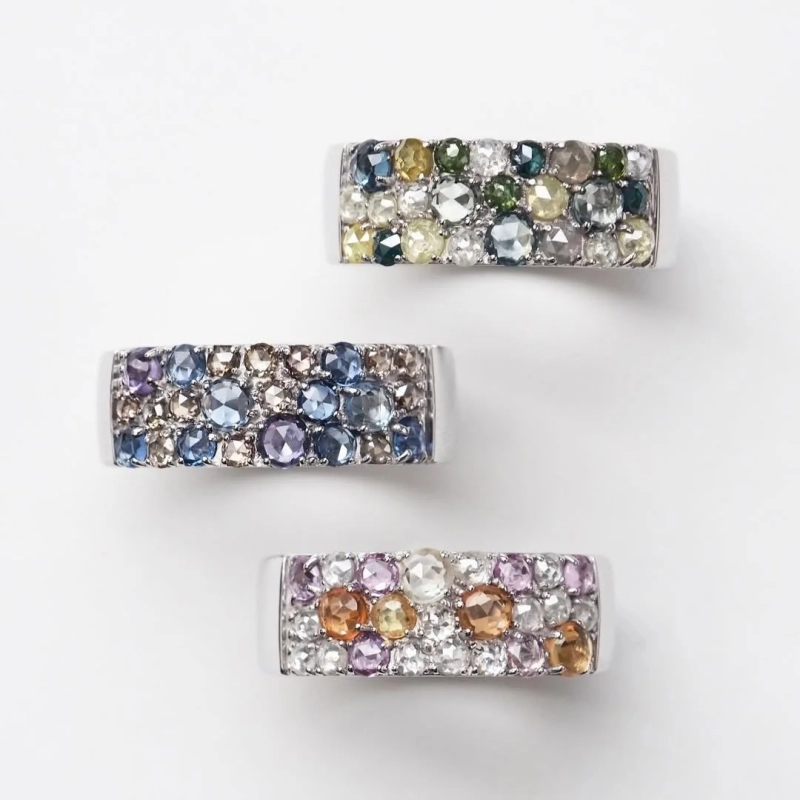 Three colorful gemstone rings on a white background