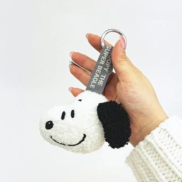 Hand holding Snoopy Face Tag Mascot