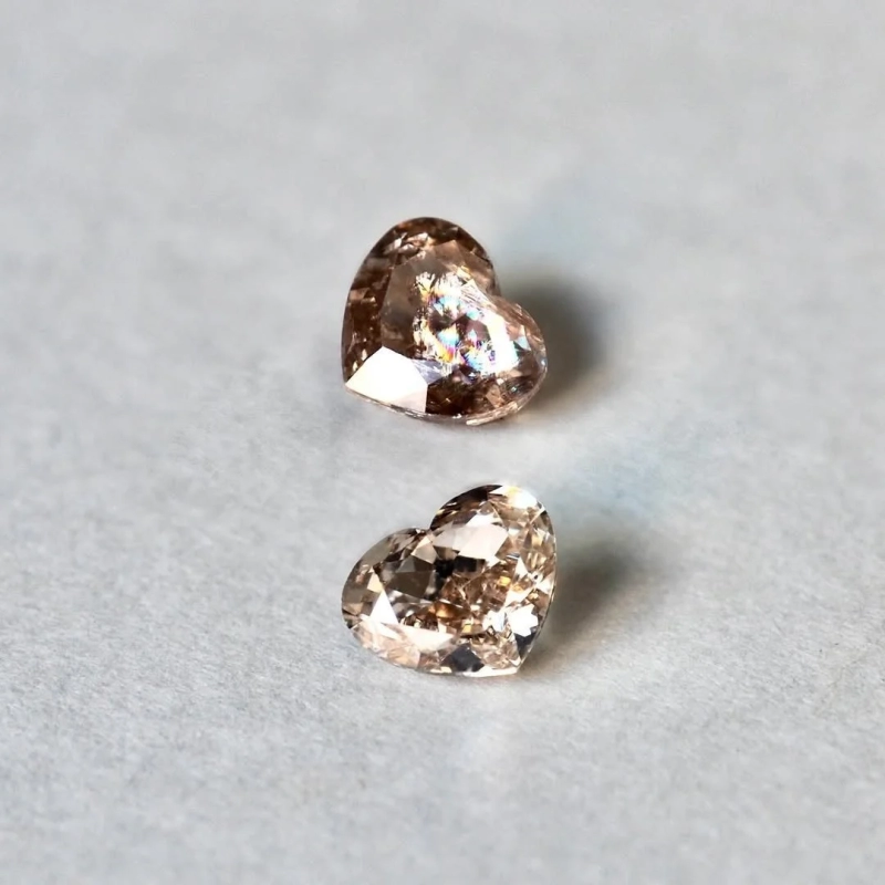 Two heart-shaped brown gemstones