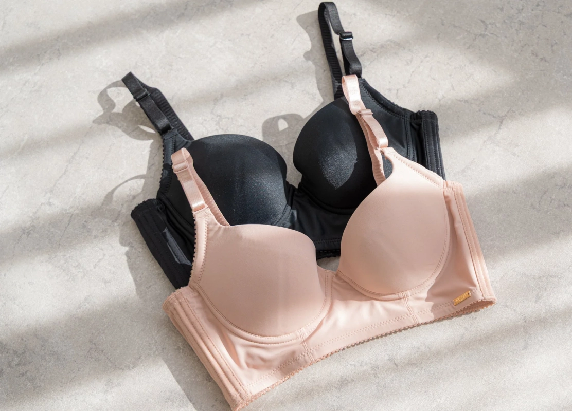 Black and beige bras layered on a light gray background