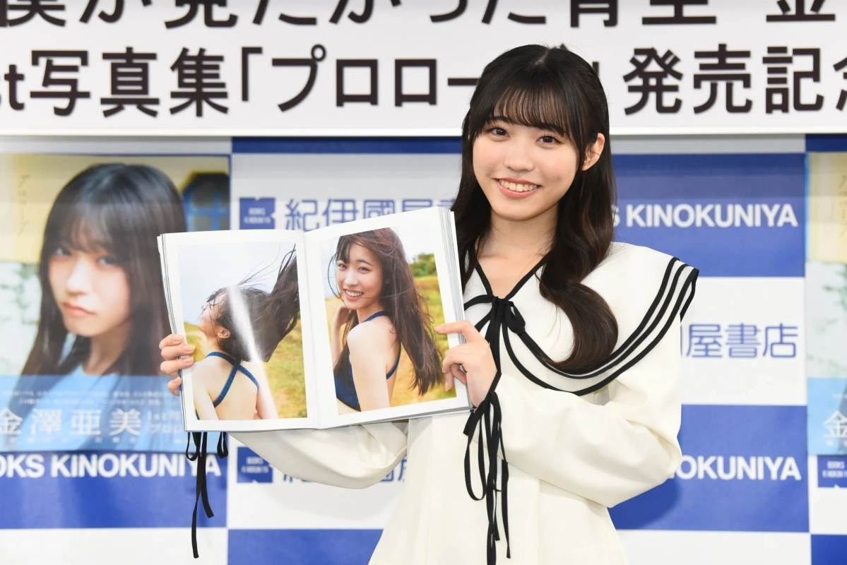 Ami Kanazawa smiling with her photobook open