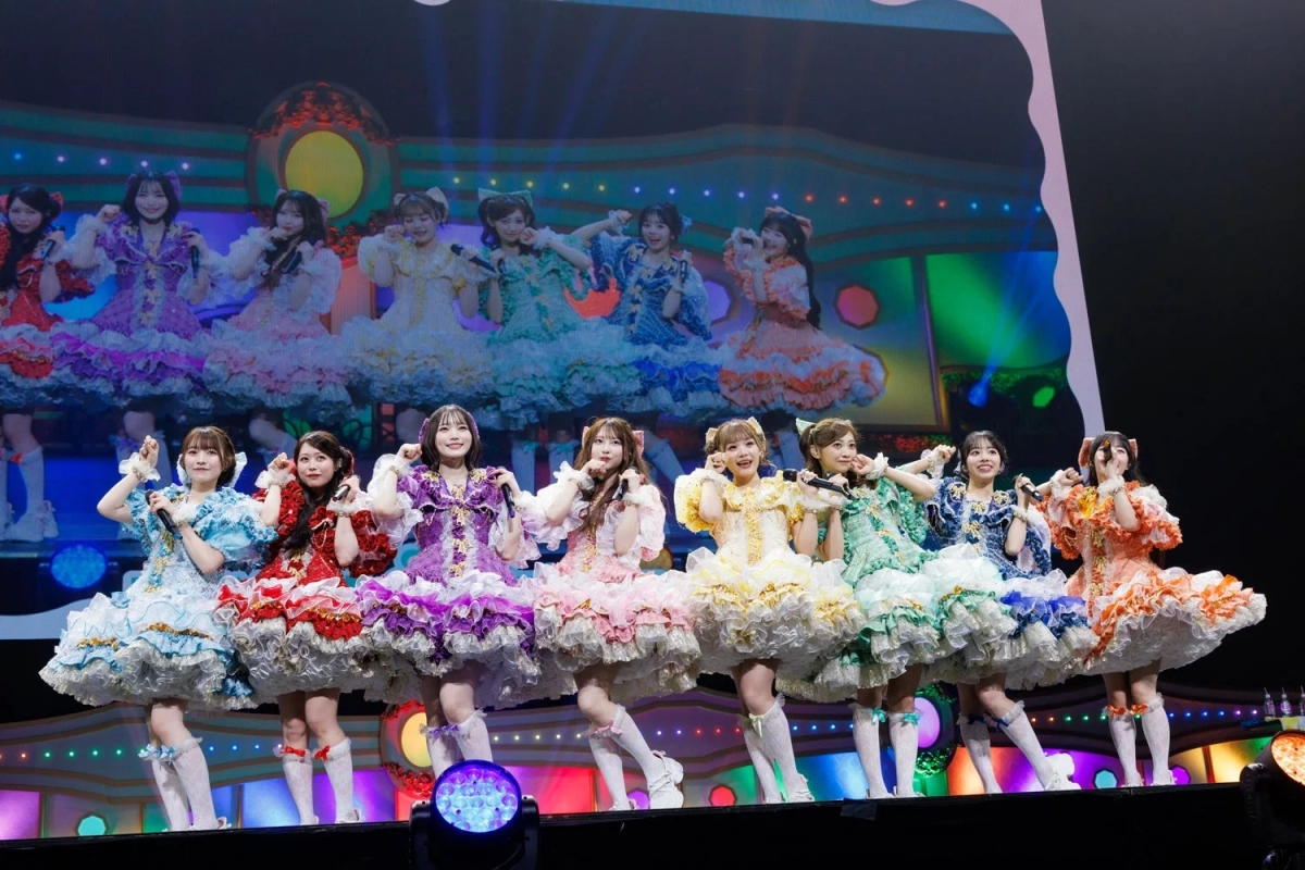 CUTIE STREET performing on stage with vibrant visuals