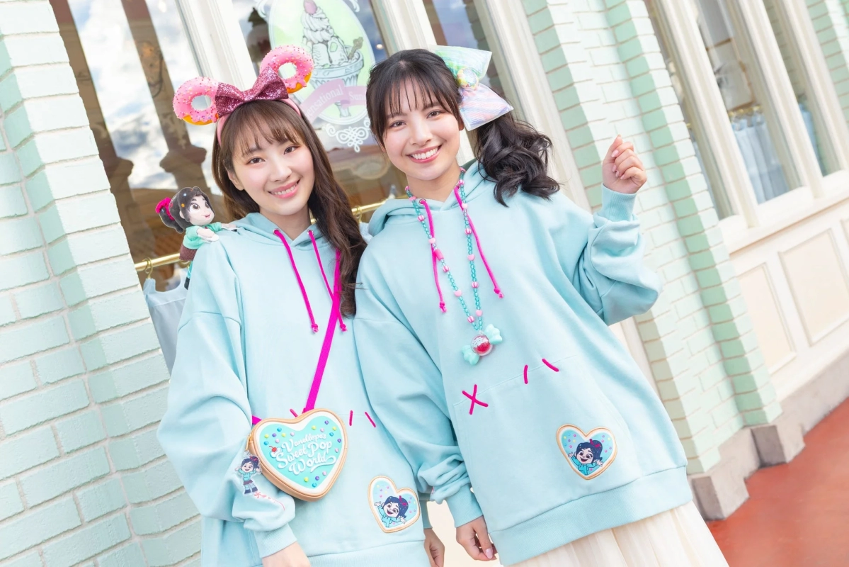 Two young women wearing Vanellope themed hoodies and donut headbands