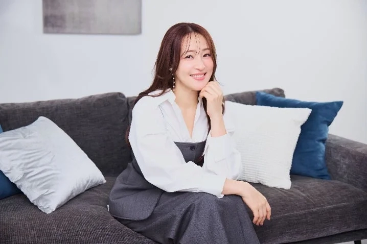 Akane Osawa smiling on a sofa