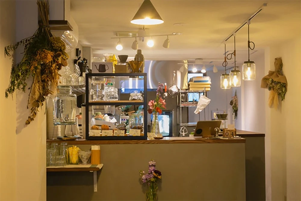 Cozy cafe interior with a counter, pastries, and flowers