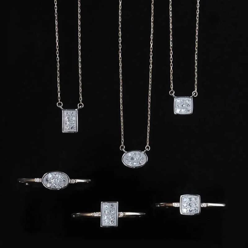 Collection of diamond necklaces and rings on black background